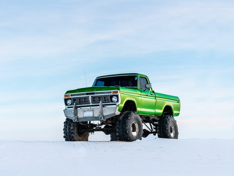 green off-road vehicle on snow during winter season