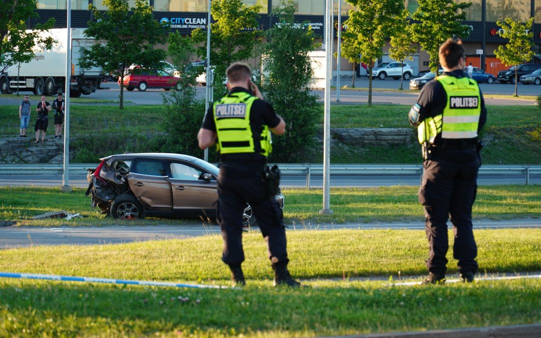 two police officers standing in front of a car